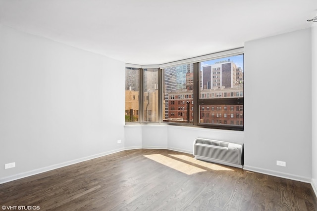 221 E Walton Pl Unit 10B, Chicago, IL 60611 - empty room featuring wood finished floors, baseboards, a city view, and an AC wall unit