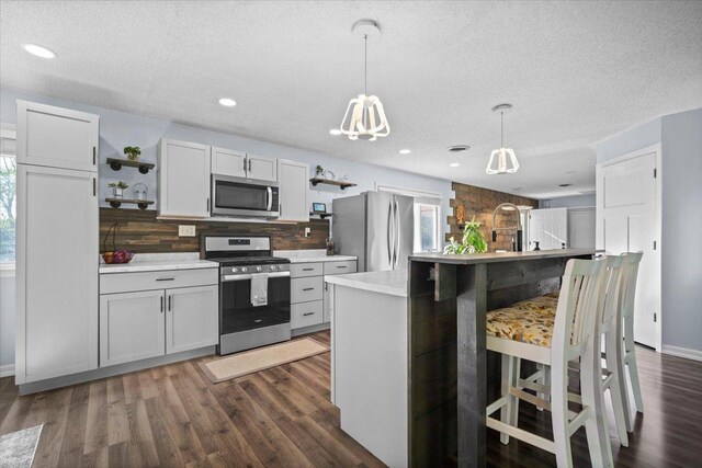 475 E Clay St, El Paso, IL 61738 - kitchen featuring appliances with stainless steel finishes, open shelves, decorative backsplash, dark wood-style floors, and a textured ceiling