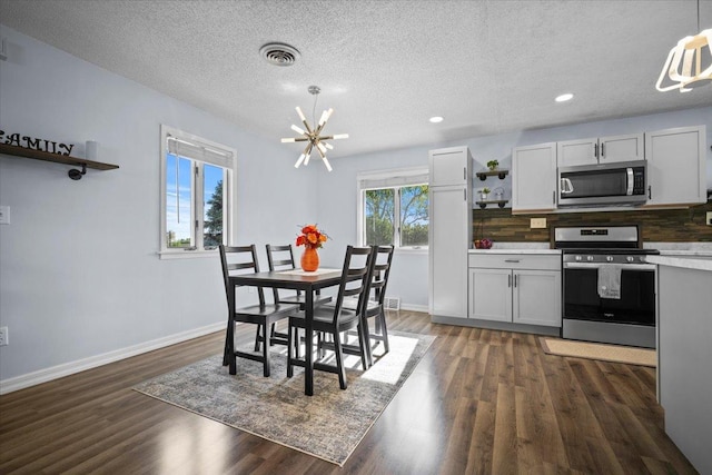 475 E Clay St, El Paso, IL 61738 - dining area featuring a chandelier, baseboards, dark wood-style floors, a textured ceiling, and recessed lighting