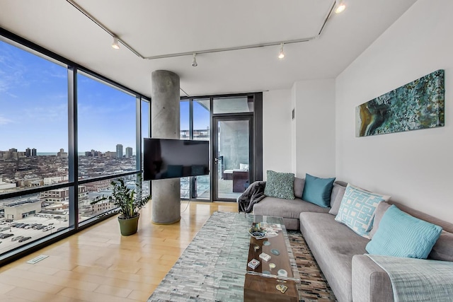 living room featuring floor to ceiling windows, track lighting, and wood finished floors