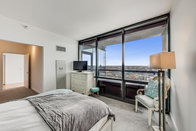 carpeted bedroom featuring floor to ceiling windows and baseboards