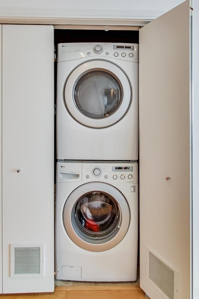 laundry room featuring stacked washer / drying machine