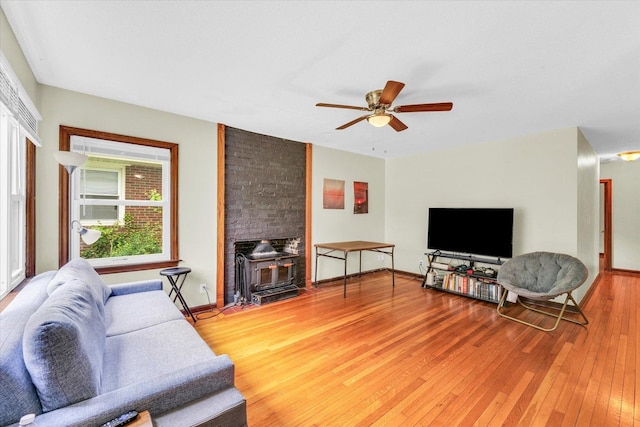 608 Hessel Blvd, Champaign, IL 61820 - living room featuring a wood stove, light wood-style floors, a ceiling fan, and baseboards
