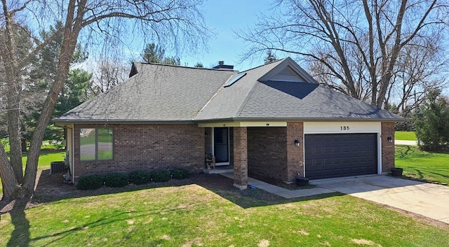 view of front of property with an attached garage, brick siding, a front yard, and concrete driveway