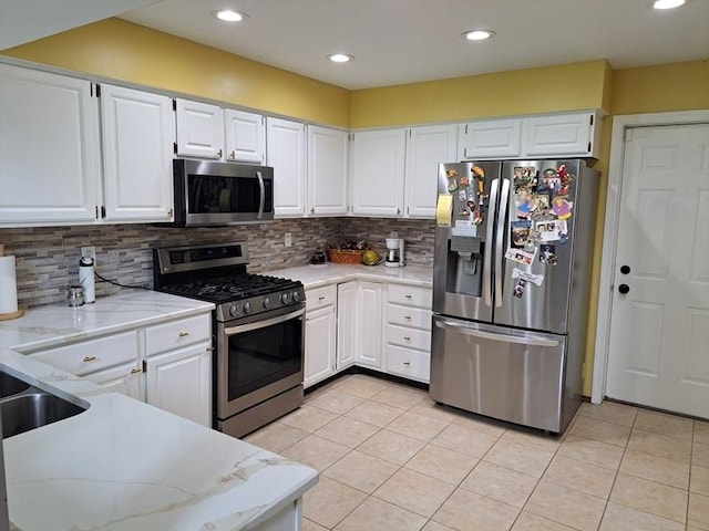 kitchen featuring stainless steel appliances, light tile patterned floors, backsplash, white cabinets, and recessed lighting