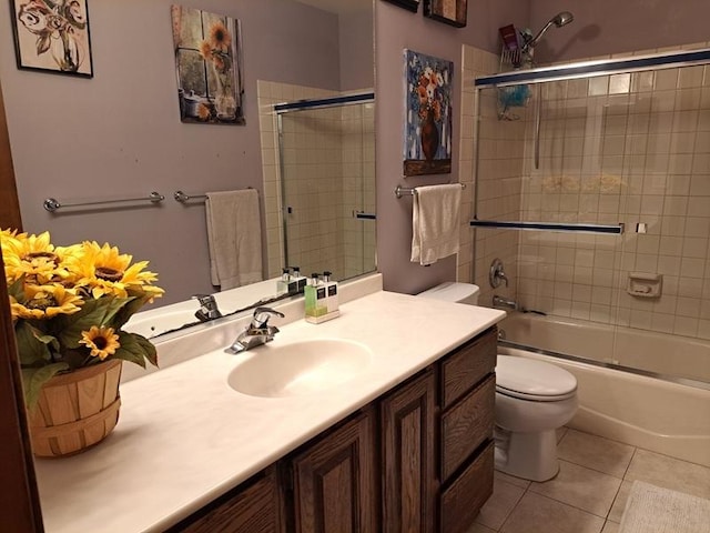 bathroom with toilet, tile patterned floors, vanity, and combined bath / shower with glass door