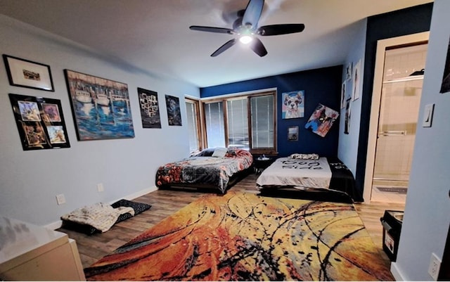 bedroom with wood finished floors, baseboards, connected bathroom, and ceiling fan