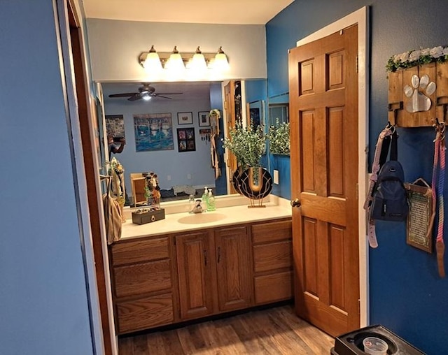 bathroom featuring wood finished floors, a ceiling fan, and vanity