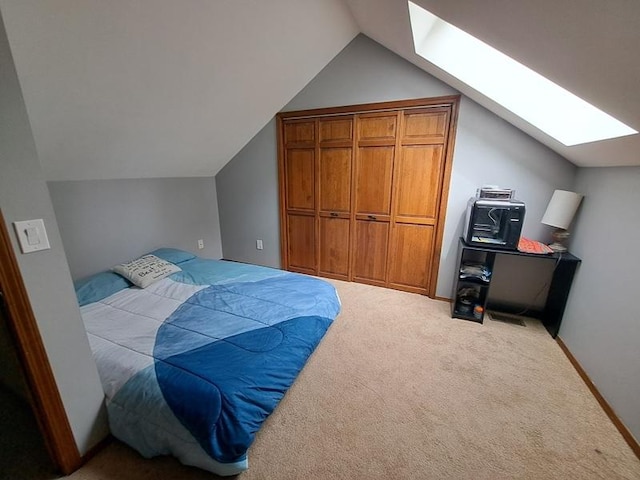 bedroom with a skylight, vaulted ceiling, and carpet