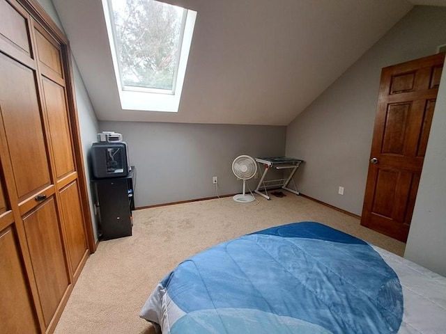 bedroom featuring lofted ceiling, a skylight, light carpet, and baseboards