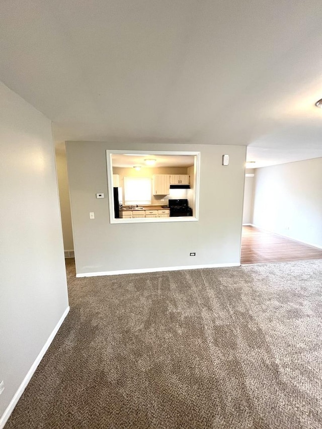 spare room featuring carpet and baseboards