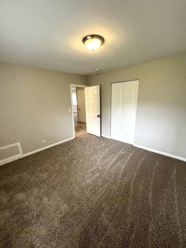 unfurnished bedroom with baseboards, carpet floors, and a closet