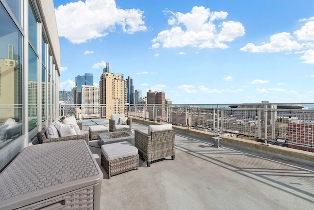 view of patio / terrace featuring an outdoor living space with a fire pit, a skyline view, and a water view