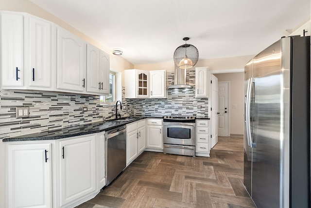 kitchen with stainless steel appliances, a sink, dark countertops, and white cabinets