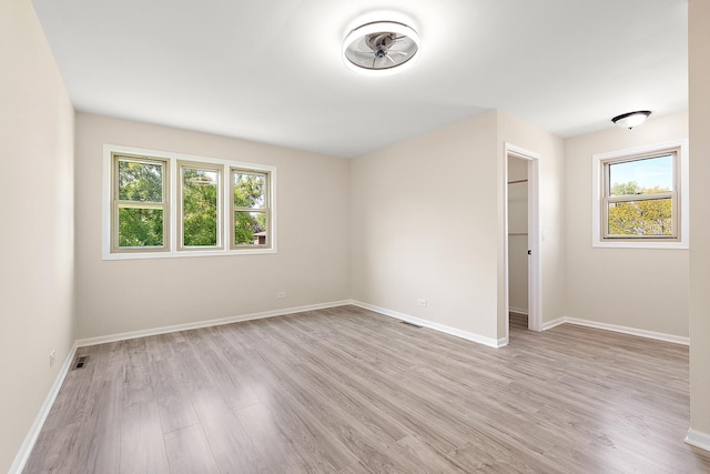 spare room featuring light wood-style floors and baseboards