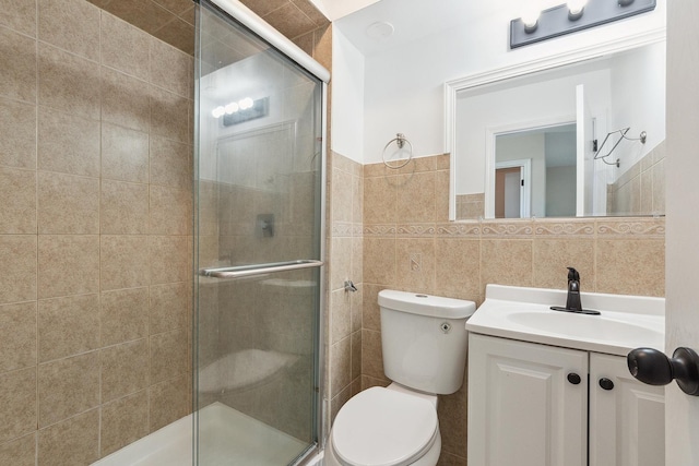 full bath with a shower stall, tile walls, toilet, and vanity