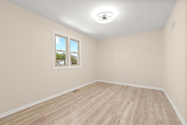empty room featuring light wood-style flooring and baseboards