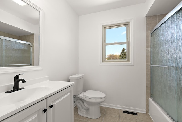 full bath with tile patterned floors, vanity, toilet, baseboards, and shower / bath combination with glass door
