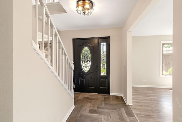 foyer featuring stairway and baseboards