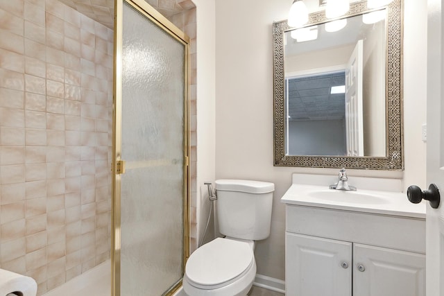full bath featuring a stall shower, vanity, toilet, and baseboards