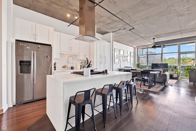 50 E 16th St Unit 312, Chicago, IL 60616 - kitchen with stainless steel fridge, island exhaust hood, dark wood-style floors, gas stovetop, and white cabinets