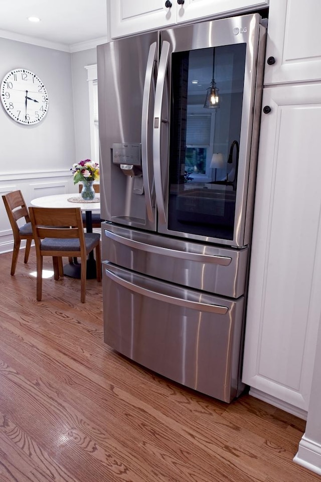 4937 N Opal Ave, Norridge, IL 60706 - kitchen with stainless steel refrigerator with ice dispenser, ornamental molding, light wood finished floors, and white cabinets