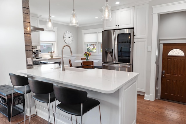 4937 N Opal Ave, Norridge, IL 60706 - kitchen with stainless steel fridge with ice dispenser, a sink, a kitchen breakfast bar, ornamental molding, and white cabinets