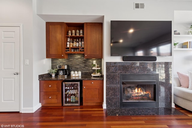 1907 W Chicago Ave Unit 3, Chicago, IL 60622 - indoor dry bar with wine cooler, dark wood-type flooring, tasteful backsplash, a tile fireplace, and baseboards