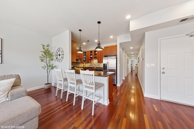 1907 W Chicago Ave Unit 3, Chicago, IL 60622 - kitchen featuring stainless steel appliances, glass insert cabinets, brown cabinets, baseboards, and a kitchen bar