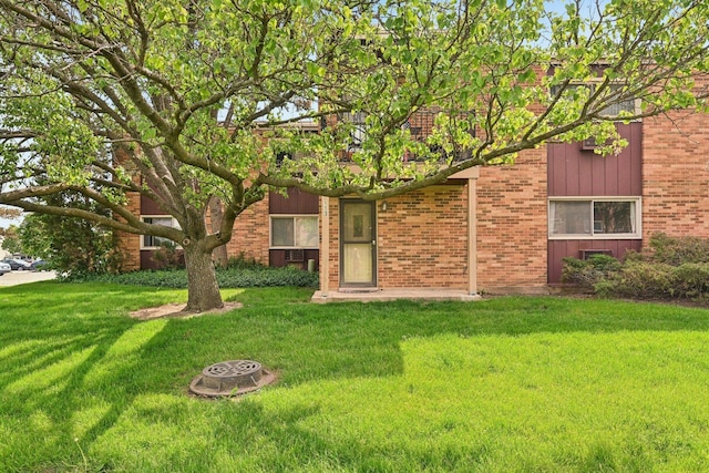 view of front of property with a front lawn and brick siding