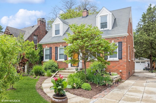 496 Longcommon Rd, Riverside, IL 60546 - cape cod-style house featuring brick siding, a chimney, and an outbuilding