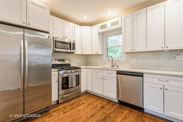 496 Longcommon Rd, Riverside, IL 60546 - kitchen with appliances with stainless steel finishes, a sink, light countertops, dark wood-style flooring, and white cabinetry