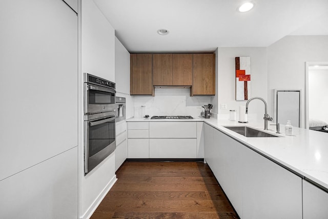 240 E Illinois St Unit 1004, Chicago, IL 60611 - kitchen featuring a sink, stainless steel double oven, dark wood finished floors, recessed lighting, and white cabinets