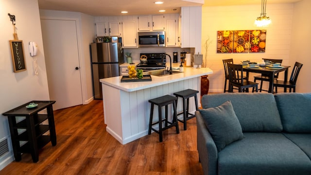 139 Walnut Hill Dr, Galena, IL 61036 - kitchen with appliances with stainless steel finishes, light countertops, white cabinets, a peninsula, and recessed lighting