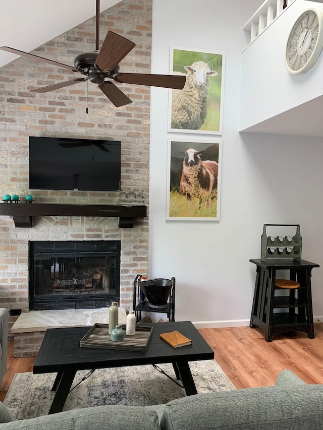 139 Walnut Hill Dr, Galena, IL 61036 - living area featuring wood finished floors, ceiling fan, high vaulted ceiling, a large fireplace, and baseboards