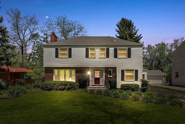 255 Irving Blvd, Chicago Heights, IL 60411 - colonial-style house with a chimney, a lawn, an outdoor structure, brick siding, and a garage