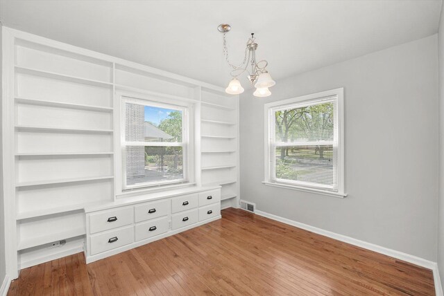 255 Irving Blvd, Chicago Heights, IL 60411 - empty room with a chandelier, light wood finished floors, baseboards, and built in features