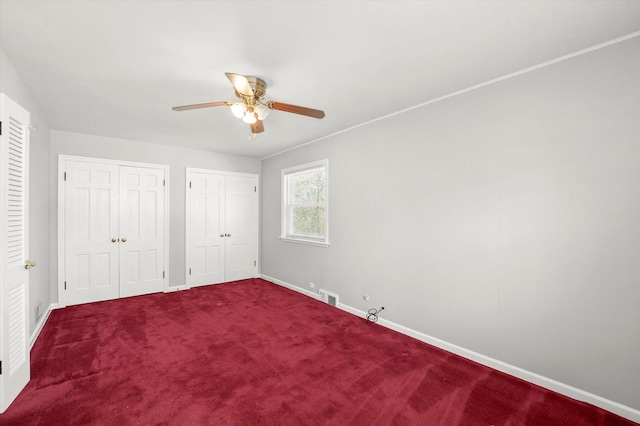 255 Irving Blvd, Chicago Heights, IL 60411 - unfurnished bedroom with multiple closets, baseboards, dark carpet, and a ceiling fan
