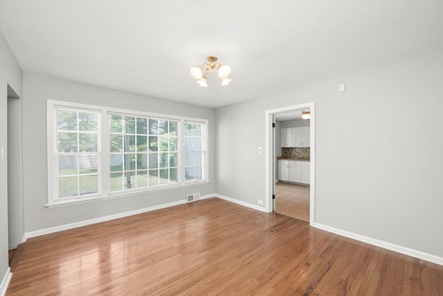 255 Irving Blvd, Chicago Heights, IL 60411 - unfurnished room featuring a chandelier, wood finished floors, and baseboards