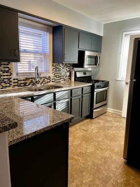 14230 S State St, Riverdale, IL 60827 - kitchen with stainless steel appliances, backsplash, a sink, dark stone countertops, and gray cabinets
