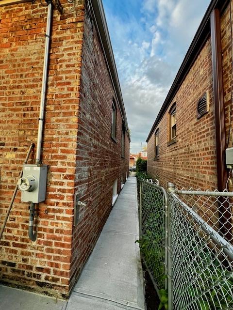 14230 S State St, Riverdale, IL 60827 - view of property exterior featuring brick siding, fence, and a gate