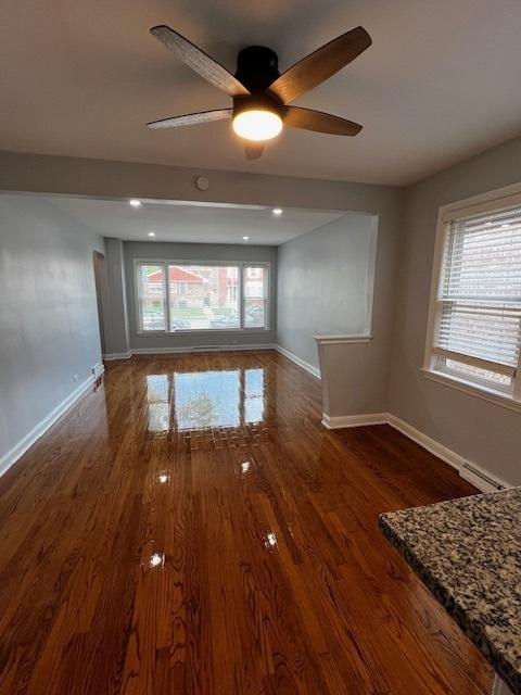 14230 S State St, Riverdale, IL 60827 - unfurnished room featuring baseboards, healthy amount of natural light, a ceiling fan, and wood finished floors