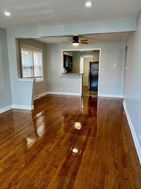 14230 S State St, Riverdale, IL 60827 - empty room with dark wood-style flooring, ceiling fan, and baseboards