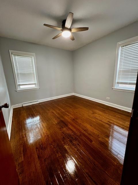 14230 S State St, Riverdale, IL 60827 - empty room featuring baseboard heating, hardwood / wood-style floors, and baseboards