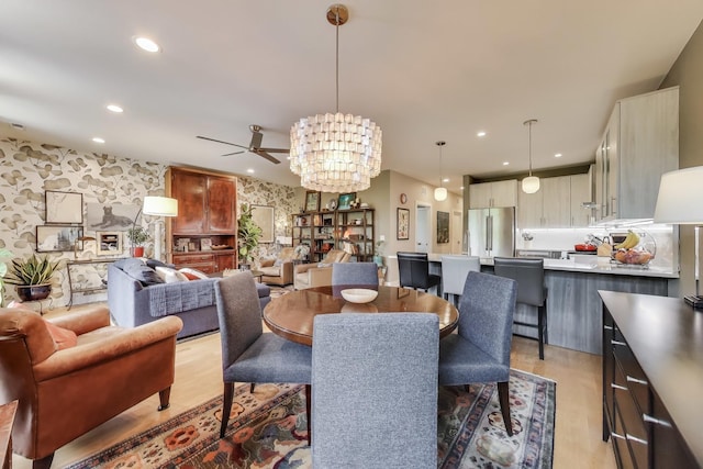 dining room with light wood-style flooring, recessed lighting, ceiling fan, and a chandelier
