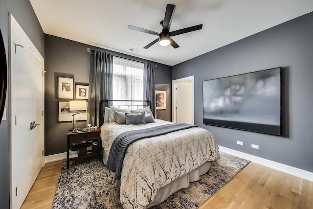 bedroom with wood finished floors, baseboards, and ceiling fan