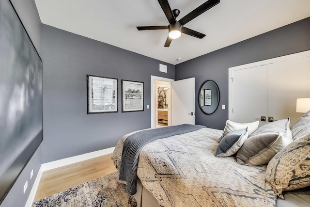 bedroom featuring wood finished floors, a closet, a ceiling fan, and baseboards