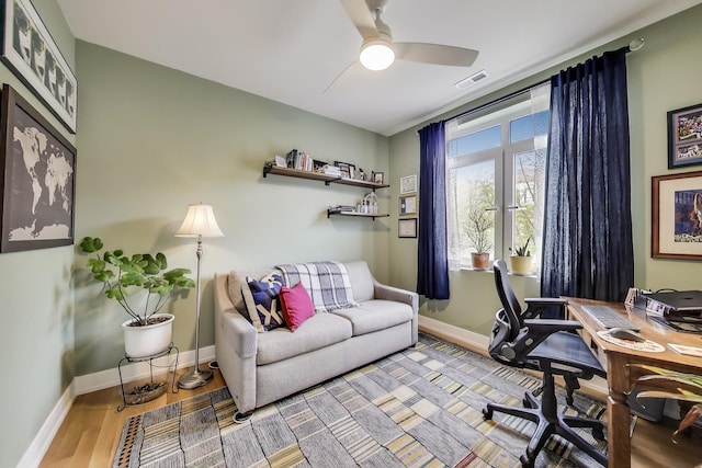 home office with a ceiling fan, baseboards, and wood finished floors