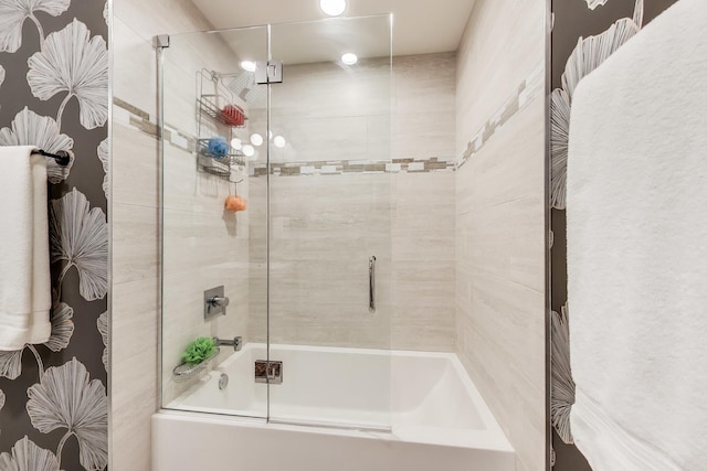 bathroom featuring combined bath / shower with glass door