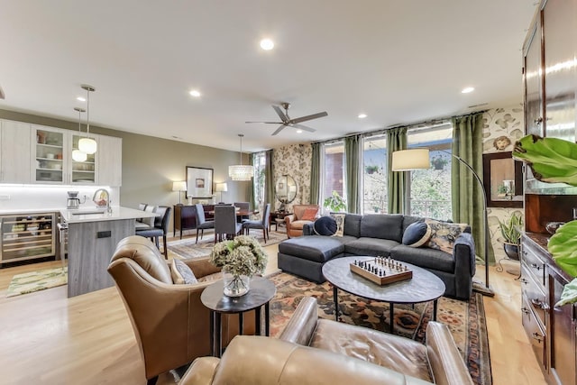 living room with wine cooler, light wood-style floors, a ceiling fan, and recessed lighting